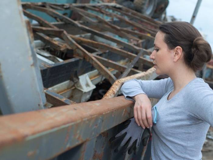 Property owner looking over storm-wrecked debris