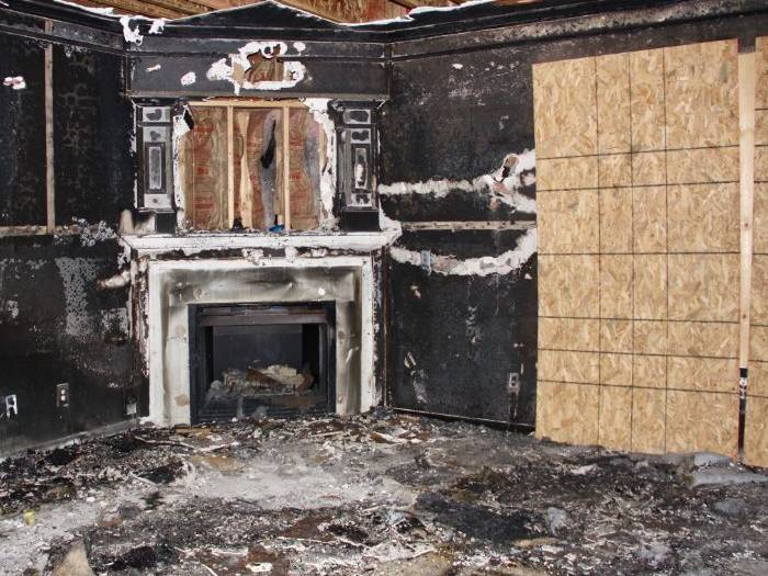 Fire-gutted living room with a charred fireplace